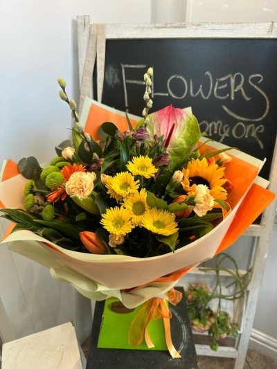 Golden Glow - A warm and uplifting bouquet filled with vibrant golden, orange and fresh green tones.